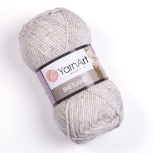 Pelote Shetland beige chiné en avant sur fond uni clair